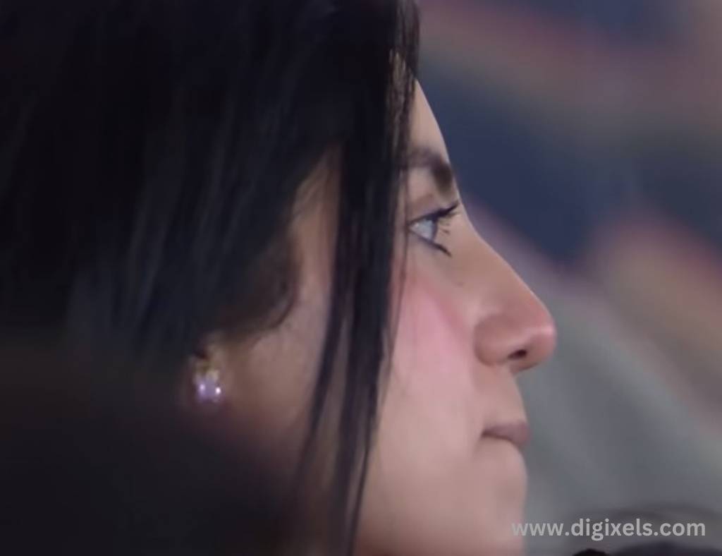 Cricket images of a lady watching cricket, face seen from side view