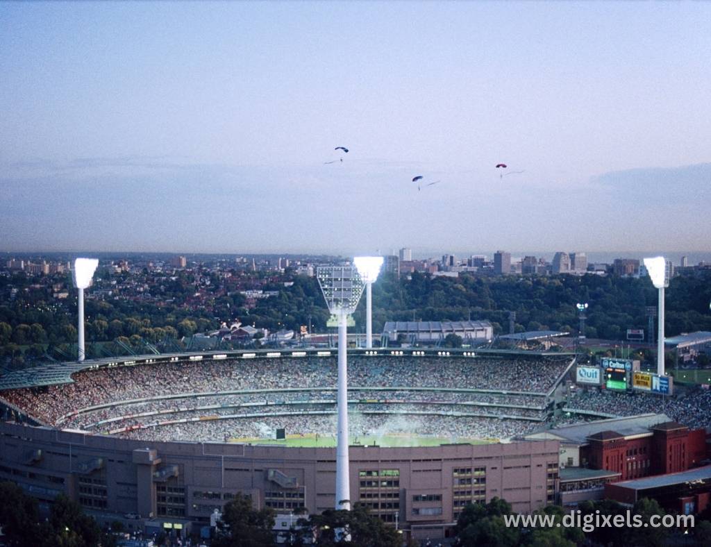 Cricket images of field ground, cricket stadium, lights on, looks bright.